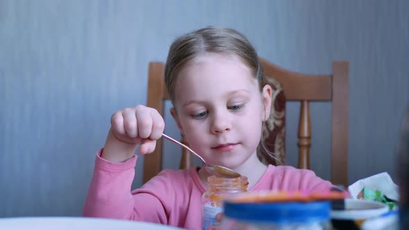 Adorable Happy Child Girl Eating Fresh Fruit Puree