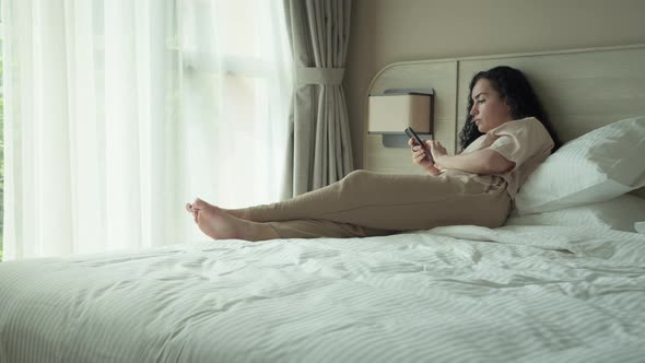 Worried Woman Using App on Cellphone at Home alt