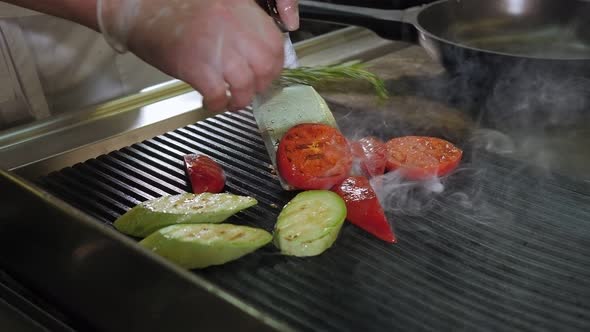 Closeup of the Restaurant's Chef Grilling Vegetables Tomato Zucchini Pepper alt