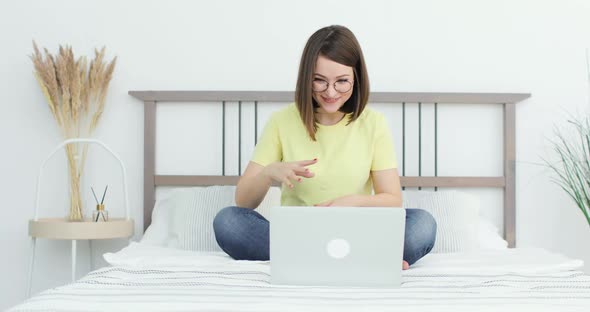 Young Beautiful Woman is Communicating with Friends Using Laptop