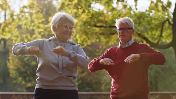 Elderly Caucasian Couple Doing Sports Together in the Park Selective Focus Medium Shot alt