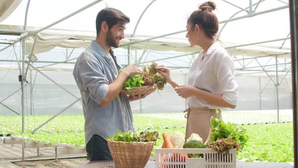 Asian businesswoman farmer show product selling  good quality plant and vegetable to hispanic man.