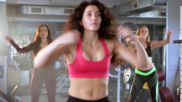Young Beautiful Female Athletes Doing Boxing Warm-up in the Gym. Fitness Training Workout.