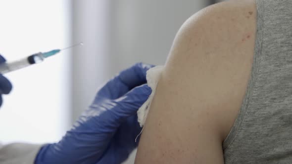 Doctor Injecting Flu Vaccine to Patient's Arm in Local Hospital