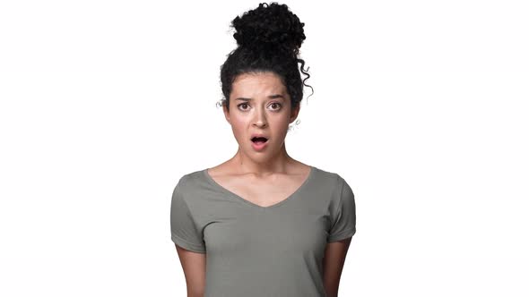 Portrait of Surprised Woman 30s with Curly Hair in Bun Shaking Head and Expressing Unexpectedness or alt