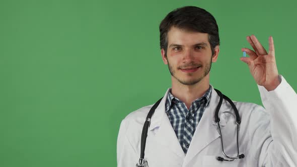 Cheerful Male Doctor Holding Vitamin Pill and an Apple alt
