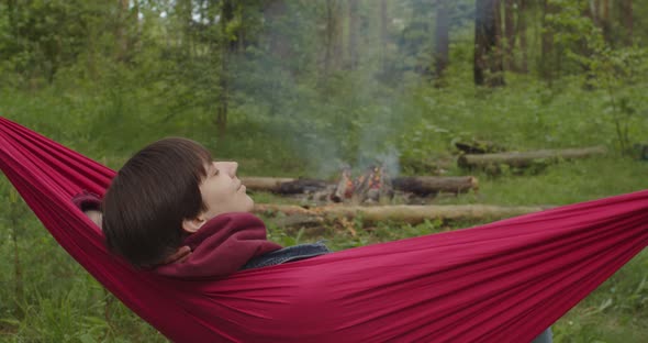 Calm Shorthaired Girl Lying in Hammock Smiling in Green Forest Woods Park