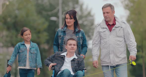 Disabled Young Man on a Walk with His Family
