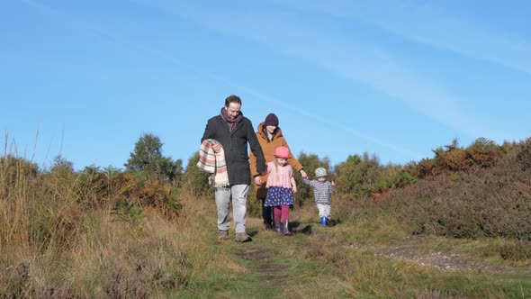 Happy family walking together in the countryside on a sunny autumn day - Pare alt