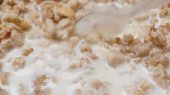 Cornflakes and cereales mixing in the bowl with milk slow-motion 1080p FullHD video - Muesli and mil alt