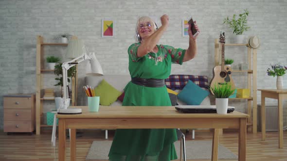 Cheerful Old Woman with Gray Hair in Headphones Listening To Music and Dancing alt