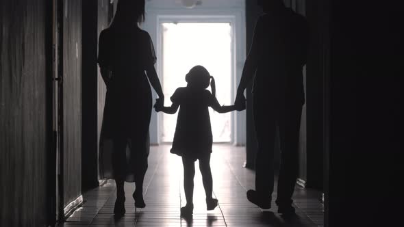 Silhouettes of Family Walking along Hallway 