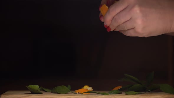 The girl cleans the delicious tangerine from the peel