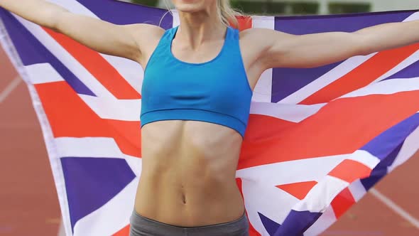 Smiling Gymnast Celebrating Victory and Holding Flag of Great Britain, Pride alt