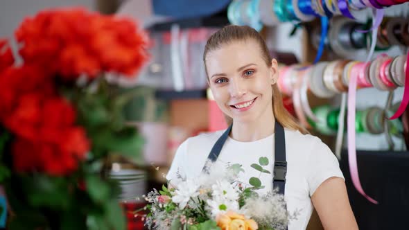 Portrait of Young Florist Female Beautiful Cheerful Woman Holds a Bouquet of Flowers in Her Hands alt