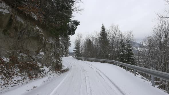 Road with cliffs on the left side in winter time alt