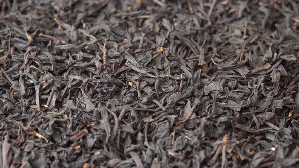 Background for a Cafe or Restaurant Tea Advertising Black Loose Leaf Tea Sprinkled on a Plate and alt