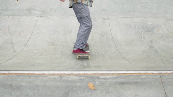 Skater Practicing in the Autumn Concrete Skate Park Making Tricks and Rides in Ramp alt
