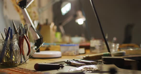 Close up of diverse jeweller tools lying on desk in workshop alt