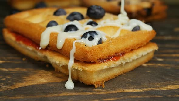 Pour White Sweet Condensed Milk Over Belgian Waffle with Blueberries