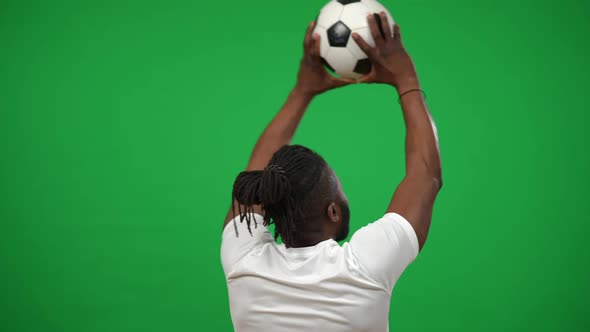 Back View Tattooed African American Man Raising Ball in Hands Rejoicing Goal at Chromakey Background alt
