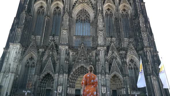 Girl Walking Towards Massive Gothic Cathedral alt