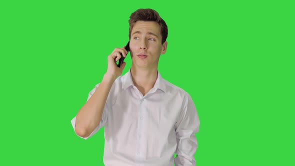 Handsome Man Having Phone Talk While Walking on a Green Screen, Chroma Key. alt