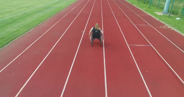 A Female Person with Disabilities Has a Workout Exercise in a Wheelchair on Training at the alt