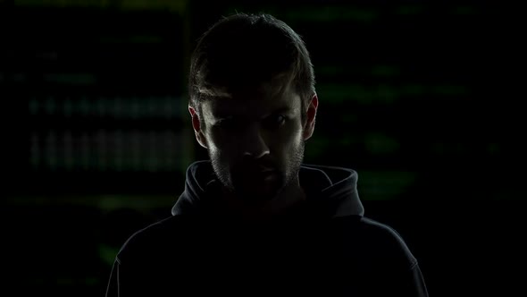 Young Incognito Man Internet Hacker Putting on Black Hood, Cybercrime Threat alt