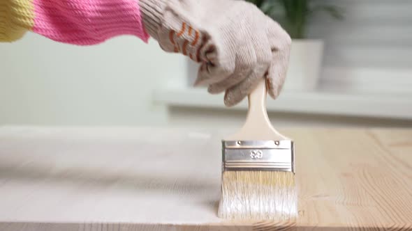 Woman Painting Wooden Table in White Color alt