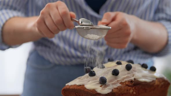 Close Up of Woman Pouring Powdered Sugar to Cake