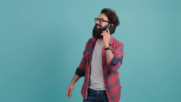 Portrait of Happy Brunette Bearded Man Having a Pleasant Mobile Conversation alt