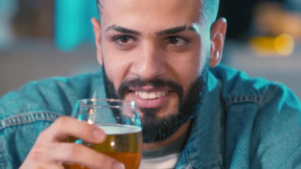 Cheerful man drinking beer with friend