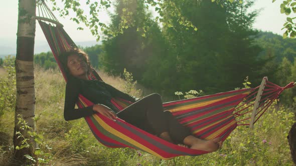 Joyful Serene African Female Tourist Sleeping in Hammock on Mountain Hill at Dawn alt