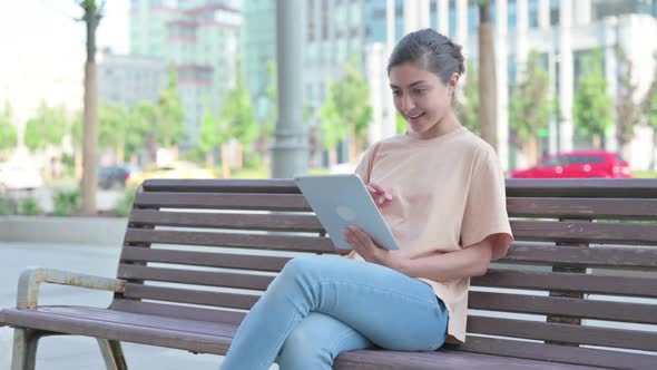 Indian Woman Celebrating Online Win on Tablet alt