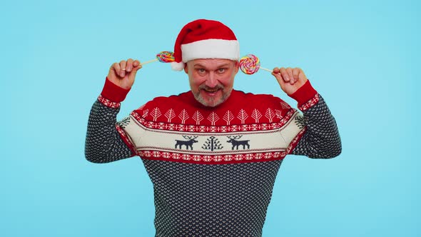 Funny Man in Red New Year Sweater Holding Candy Striped Lollipops Hiding Behind Them Fooling Around alt