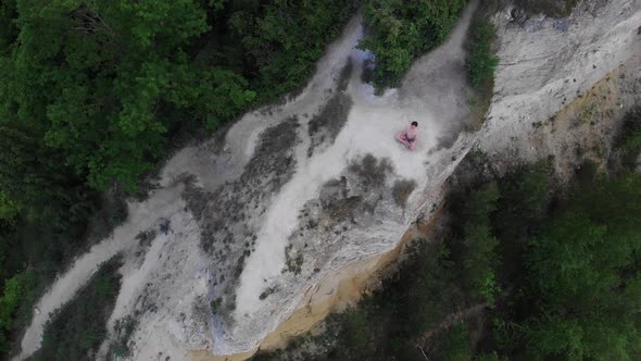 Young Shirtless Man Meditating on a Mountain Around the Forest in Early Morning alt