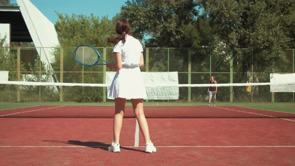 Female Tennis Player Shooting Ball To Opponent