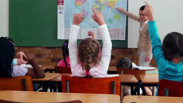 Little Children Listening to Teacher Showing the Map in Classroom alt