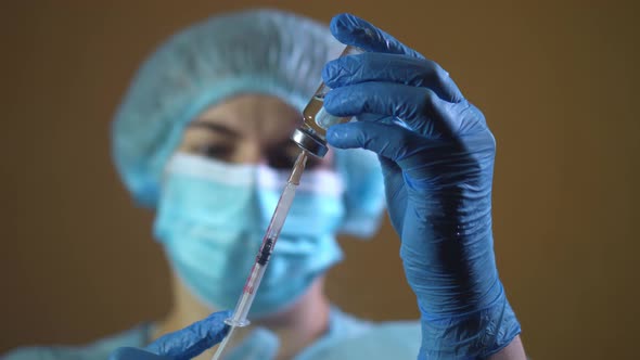 Doctor in Latex Gloves Fill in Syringe with Medicine From Glass Vial Close Up alt
