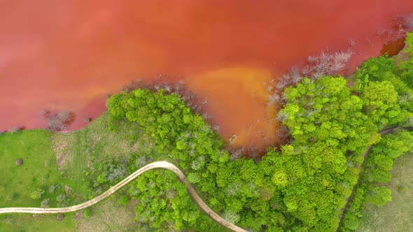 Flying Above Colorful Mining Waste Water and Green Forest alt