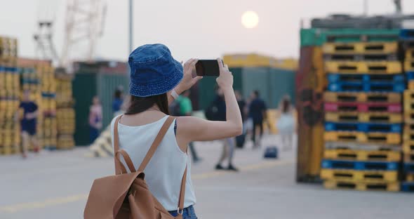 Woman take photo on cellphone in city alt