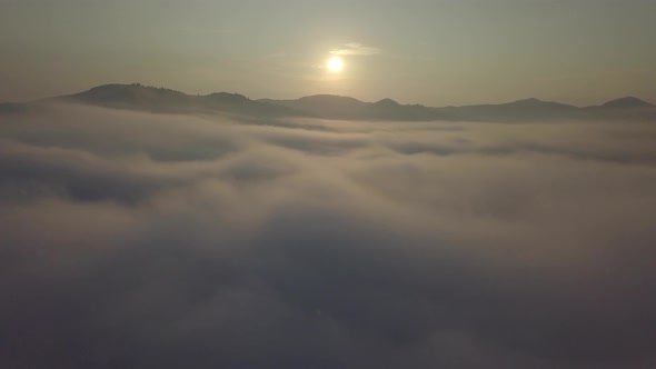 Aerial drone view of foggy sunrise over clouds hills and mountains at morning Carpathian mountains