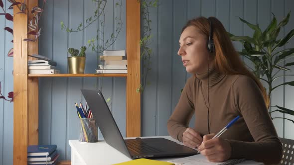 Woman Wear Headphone Study Online with Internet Teacher Learn Language Talk Looking at Laptop