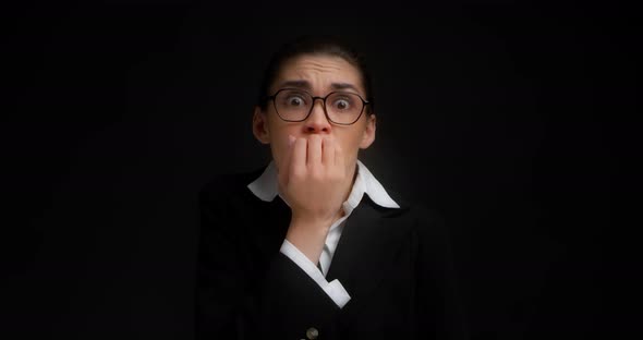An Excited Young Business Woman with Glasses Biting Her Nails alt