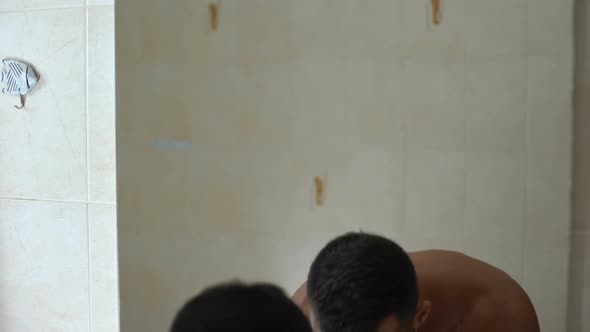 Purposeful Man Washes Face in Front of Mirror, Self-Motivation Before Date alt