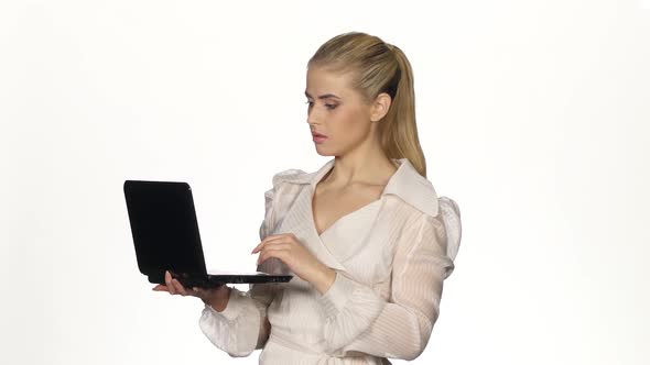Young Businesswoman Works on Notebook and Smiles. White alt