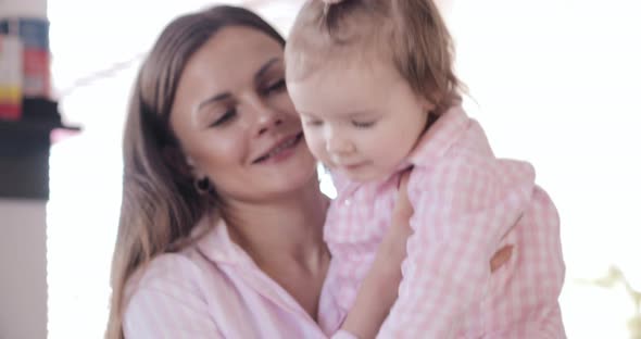 Mother with Daughter Standing at Kitchen and Drinking Coffee