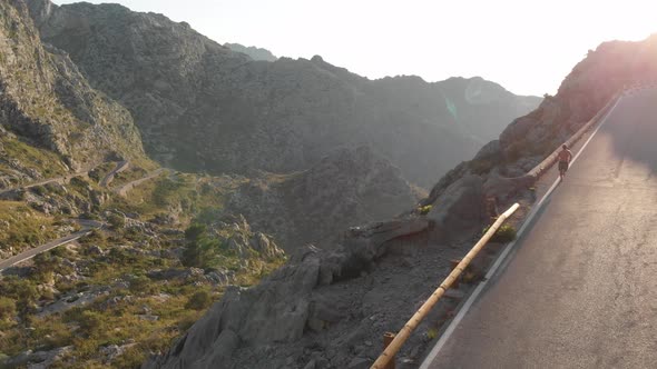 Aerial view, guy running on the road of Tramuntana mountains, Sa Calobra, Mallorca alt