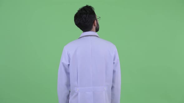 Profile View of Young Bearded Persian Man Doctor Thinking and Examining alt